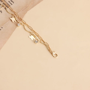 Detail of golden double-layer waist chain with butterfly pendants and crystal accents