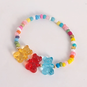 Close-up of colorful bead bracelet with three translucent resin gummy bear pendants