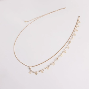 Detail of gold double-layer waist chain with butterfly pendant and sparkling rhinestones