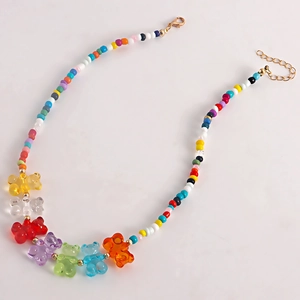 Close-up of colorful beaded necklace with seven rainbow resin bear pendants and golden clasp