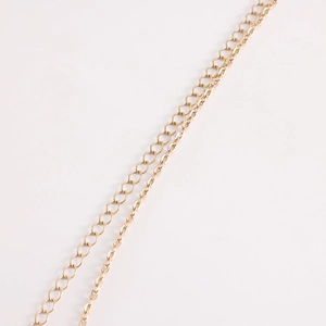 Detail of a double-layered gold metal waist chain with elegant butterfly fringe pendant