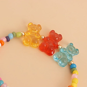 Detailed macro view of colorful translucent bear charms and vibrant beaded jewelry set