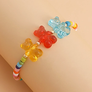 Close-up of colorful beaded bracelet featuring red, yellow, and blue resin bear charms