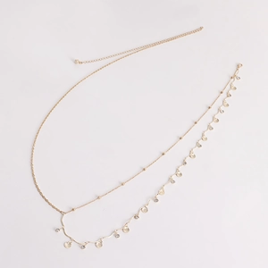 Detail of gold layered body chain featuring small scallop shells and sparkling crystals