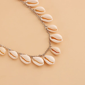 Detail of silver metal chain with white sea shell pendants for beach waist accessory