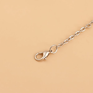 Close-up detail of silver metal chain links with a sturdy lobster clasp for beach waist jewelry