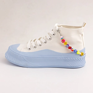 White high-top canvas shoe with smiley face beaded charm and light blue platform sole