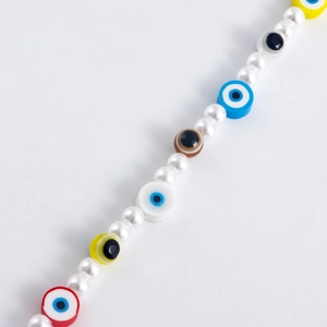 Detail of bohemian evil eye shoe chain with white pearls and colorful beads for DIY charms