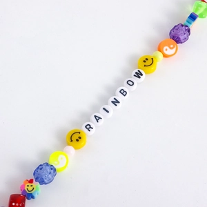Detailed close-up of colorful Y2K beads featuring rainbow letters and smiley face charms