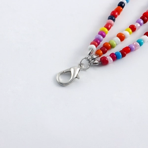Close-up of bohemian multi-color beaded layers with a silver lobster clasp attachment