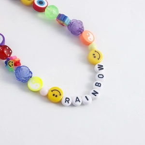 Vibrant beaded anklet with RAINBOW lettering and colorful charms like smiley faces