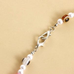 Detailed close-up of lobster clasp with white pearls and brown agate beads for anklets