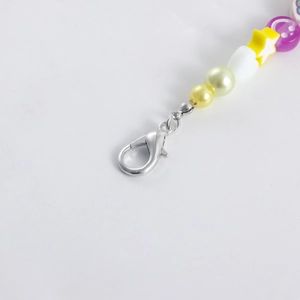 Détail d'une chaîne de perles colorées avec lettres LOVE et breloque sourire