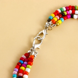 Close-up of bohemian multi-color layered beaded chain with silver metal lobster clasp