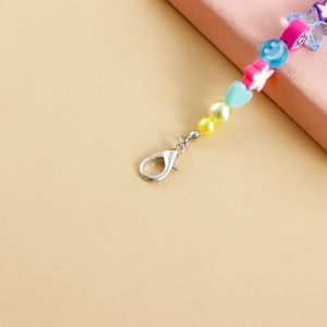Détail de perles colorées avec lettres LOVE et breloque papillon sur fermoir homard