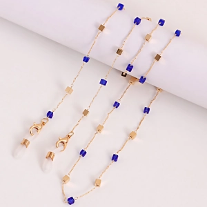 Détail de chaîne à lunettes dorée avec cubes en cristal bleu et boucles en gomme