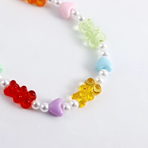 Detailed close-up of colorful resin gummy bears and white pearl beads on a cute shoe chain