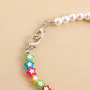 Detail of colorful acrylic star beads and white pearls with silver lobster clasp