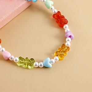 Close-up of colorful resin bear charms and faux pearls on a stylish anklet jewelry