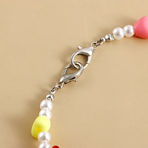 Detail of silver lobster clasps with colorful resin heart beads and white pearls
