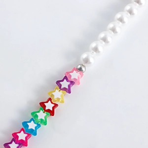 Macro shot of colorful star beads and white pearls on a stylish dopamine aesthetic shoe chain