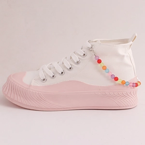Zapatillas altas blancas bohemias con suelas de plataforma rosa y cadenas de cuentas