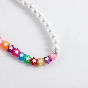 Detail of beaded shoe chain with white pearls and vibrant multicolored star-shaped beads