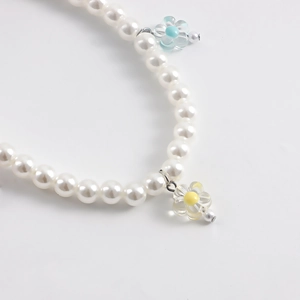 Detailed macro view of faux pearl shoe chains with exquisite blue and yellow flower charms