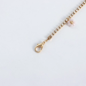 Detail of gold lobster clasp and pink beaded flower pendant with sparkling rhinestones