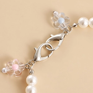 Detail shot of pearl beads and resin flower pendants with silver lobster clasps