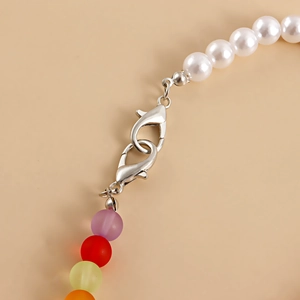 Detalle macro de cadena para zapatos con perlas blancas, cuentas de colores y cierres