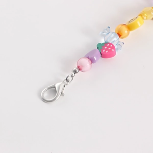Detail shot of colorful beaded shoe chain with heart, strawberry, and smiley face charms