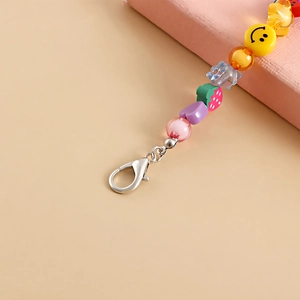 Macro detail of colorful beaded shoe charm with smiley face and heart patterns