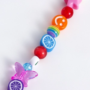 Macro detail of multi-colored fruit charms and butterfly beads for shoe decorations
