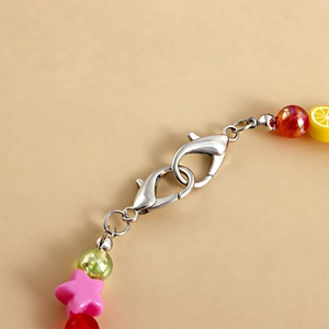 Close-up of colorful beaded shoe chain with star and lemon charms and silver lobster clasps