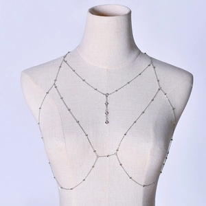 Macro shot of silver body chain with layered metal beads and zircon Y-pendant detail