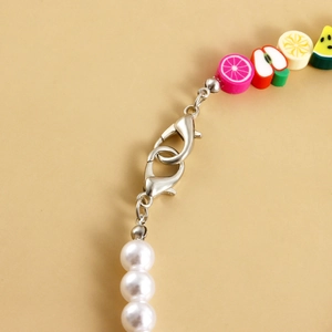 Close-up of colorful fruit clay beads and faux pearls shoe chain with lobster clasps