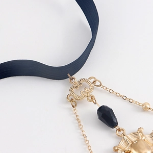 Detail of gothic leg chain featuring black elastic band and golden sun bat pendant