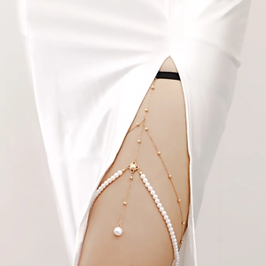 Sexy multi-layered gold leg chain with faux pearls for women wearing a white dress