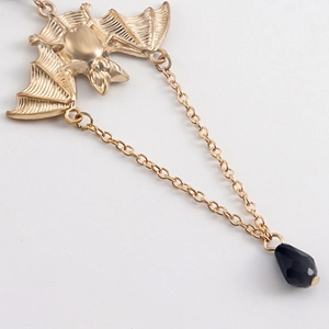 Close-up of gothic bat thigh chain with gold bat pendant and black crystal teardrop