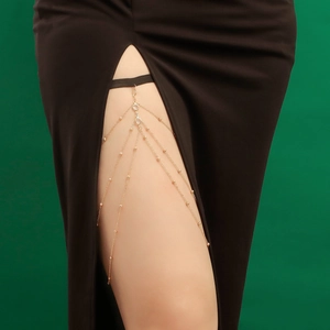 Détail d'une chaîne de cuisse dorée multicouche avec cristaux et bande élastique