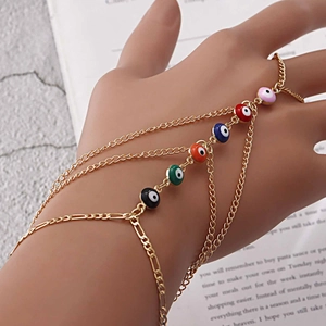 Detailansicht eines goldenen Sklavenarmbands mit sechs bunten Evil-Eye-Anhängern an der Hand