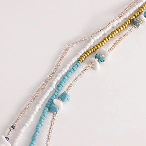 Detailed close-up of Bohemian layered body chain featuring turquoise beads and white stones