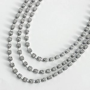 Macro shot of three-layer silver rhinestone shoe chains with sparkling square-cut crystals