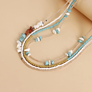 Detail showing colorful boho layered beaded body chain with turquoise and white stones