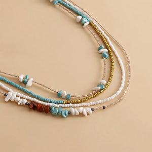 Macro detail of bohemian layered body chain with colorful turquoise and mineral stone beads