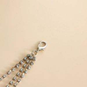 Macro detail of triple-layered silver rhinestone chains with secure lobster clasp finish