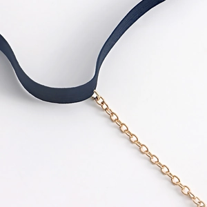 Detailed close-up of a sexy black elastic leg chain with layered gold-tone rhinestones