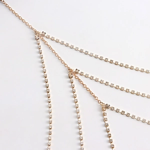 Detailed view of multi-layer gold thigh chain with sparkling rhinestone fringe accents