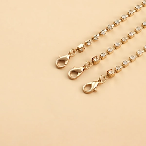 Detail of golden rhinestone layered leg chains with sparkling crystals and lobster clasp